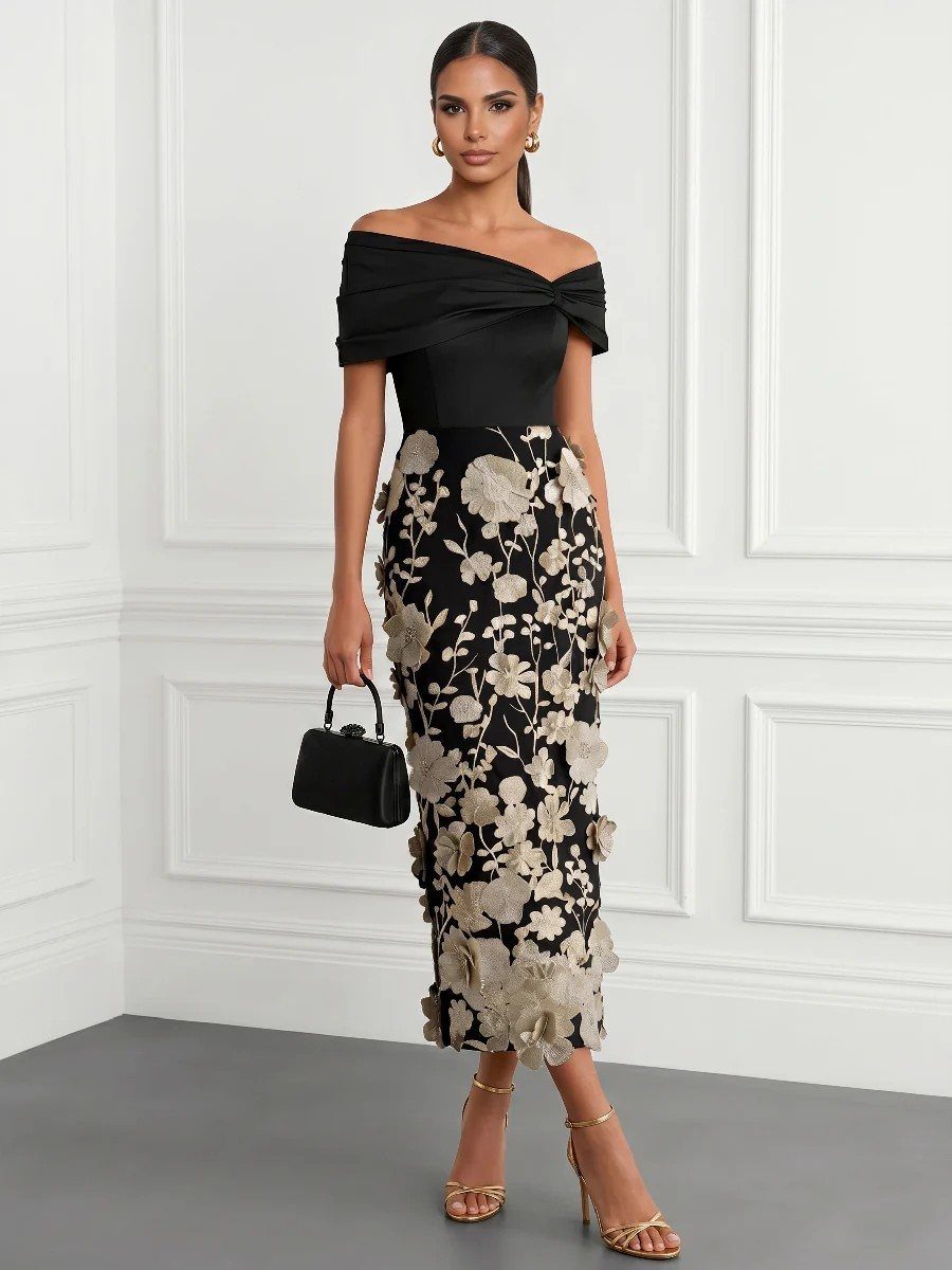 Woman in a black floral appliqué midi dress posing with a small black handbag.