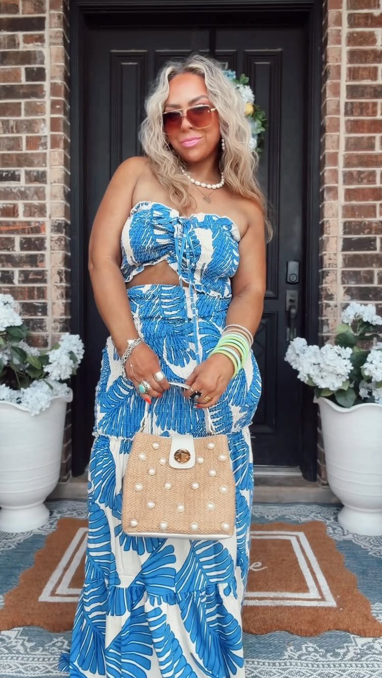 Woman wearing a blue and white tropical print strapless maxi dress and sunglasses.
