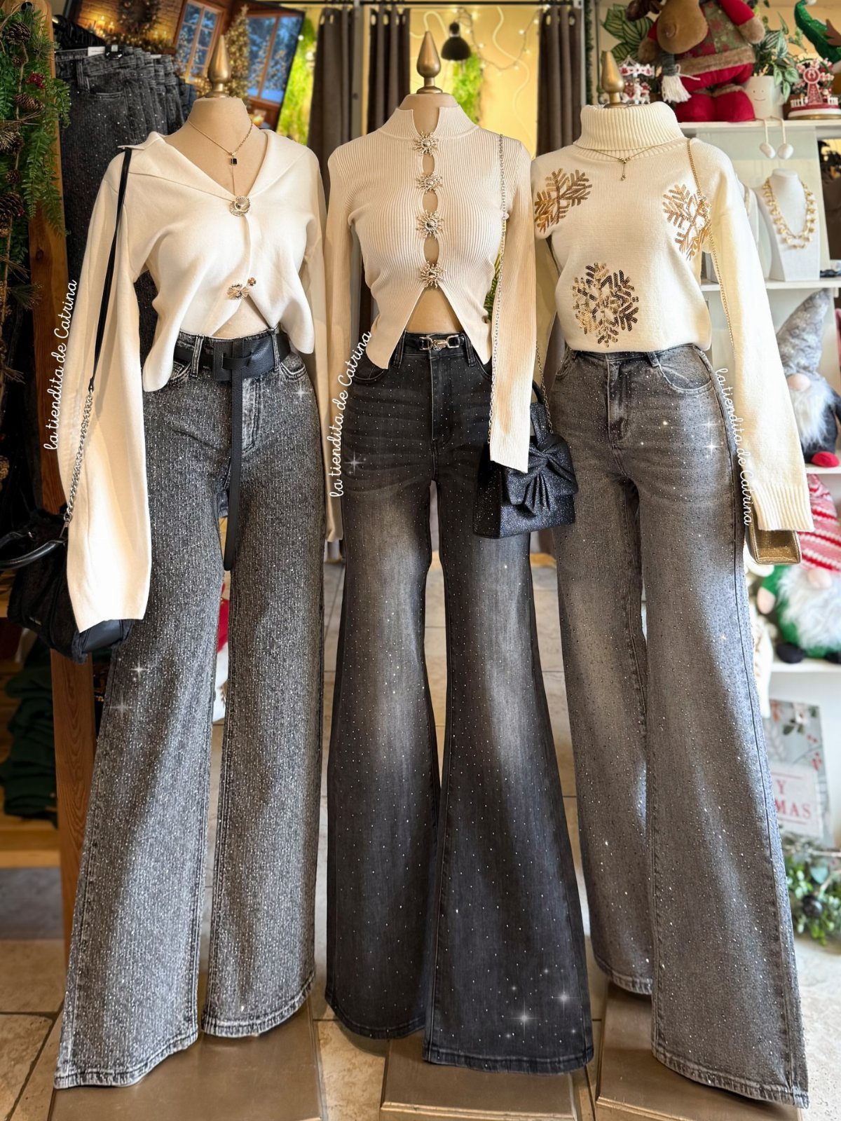 Three mannequins wearing white sweaters and glittery dark flared jeans in a boutique setting.
