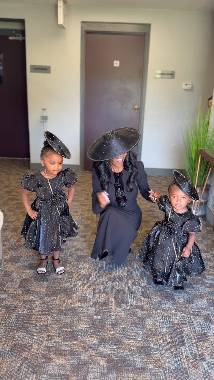 A woman and two children posing in matching sparkly black dresses and large black hats.