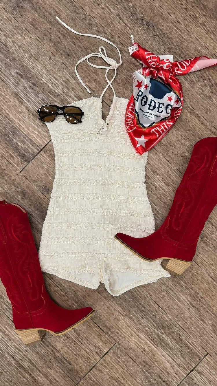 White textured romper paired with red cowgirl boots, sunglasses, and a red bandana on wood flooring.