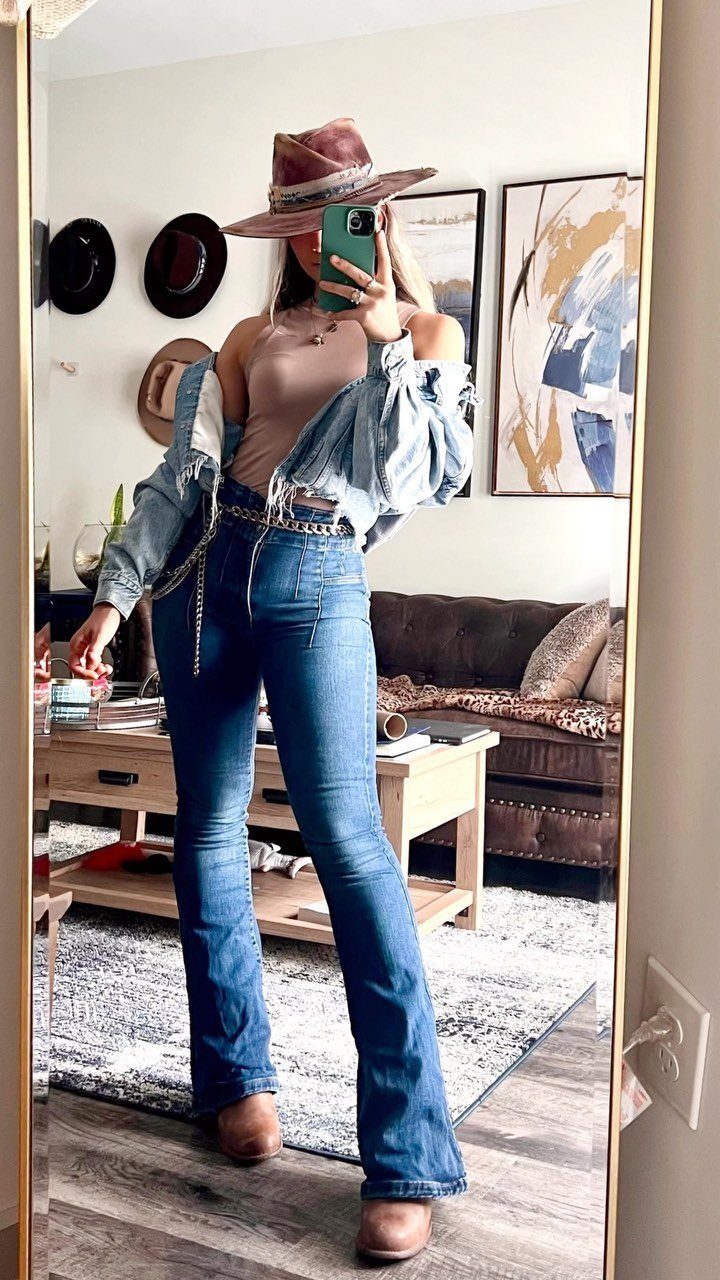 Woman in a mirror selfie wearing blue denim jeans, a denim jacket, and a cowboy hat.