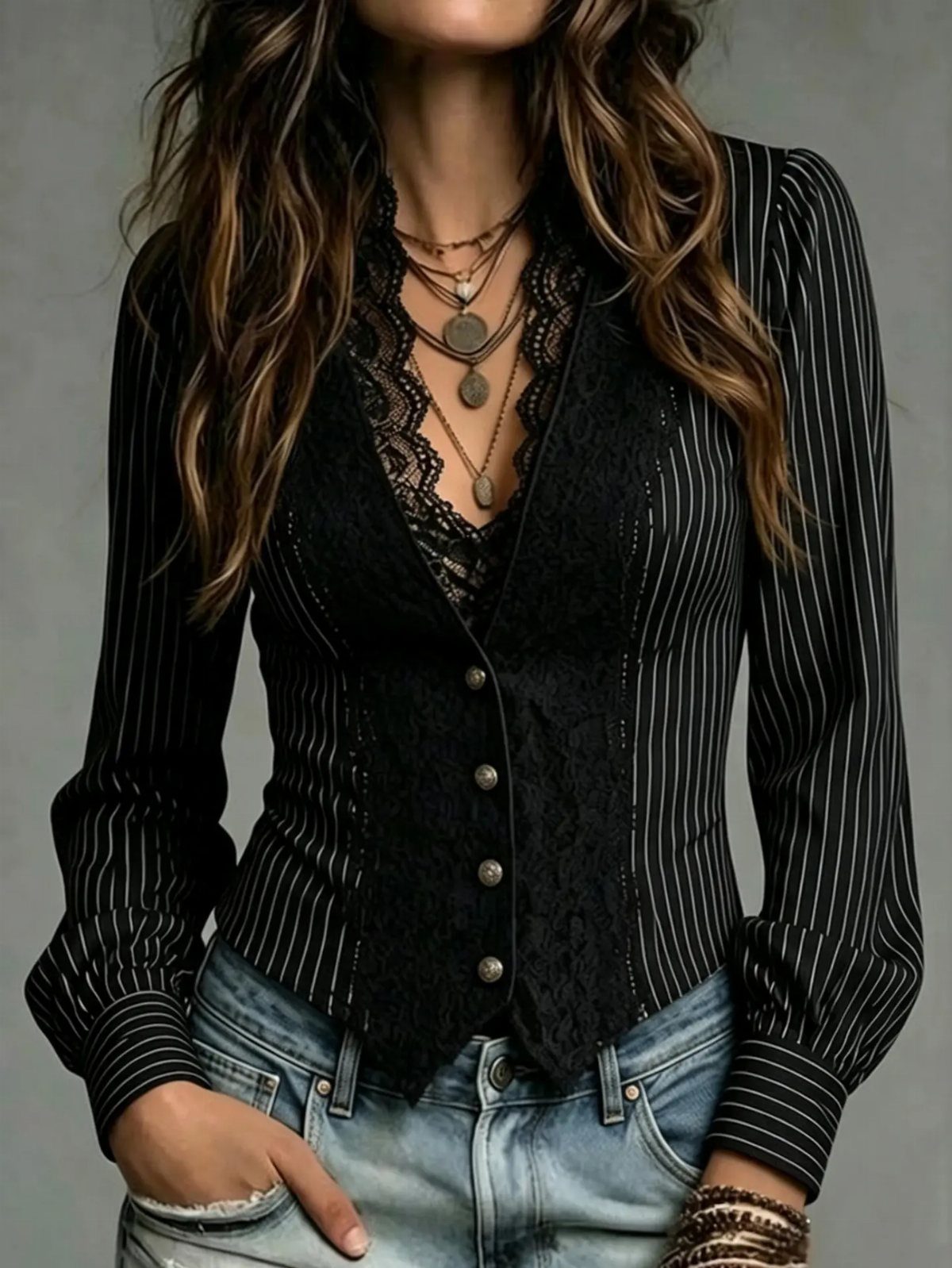 Person wearing a black pinstriped shirt, lace vest, and several layered necklaces with metallic pendants.