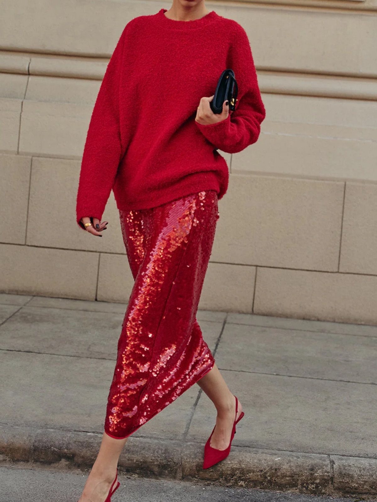 Person walking in a red fuzzy sweater, red sequined skirt, and red high heels.