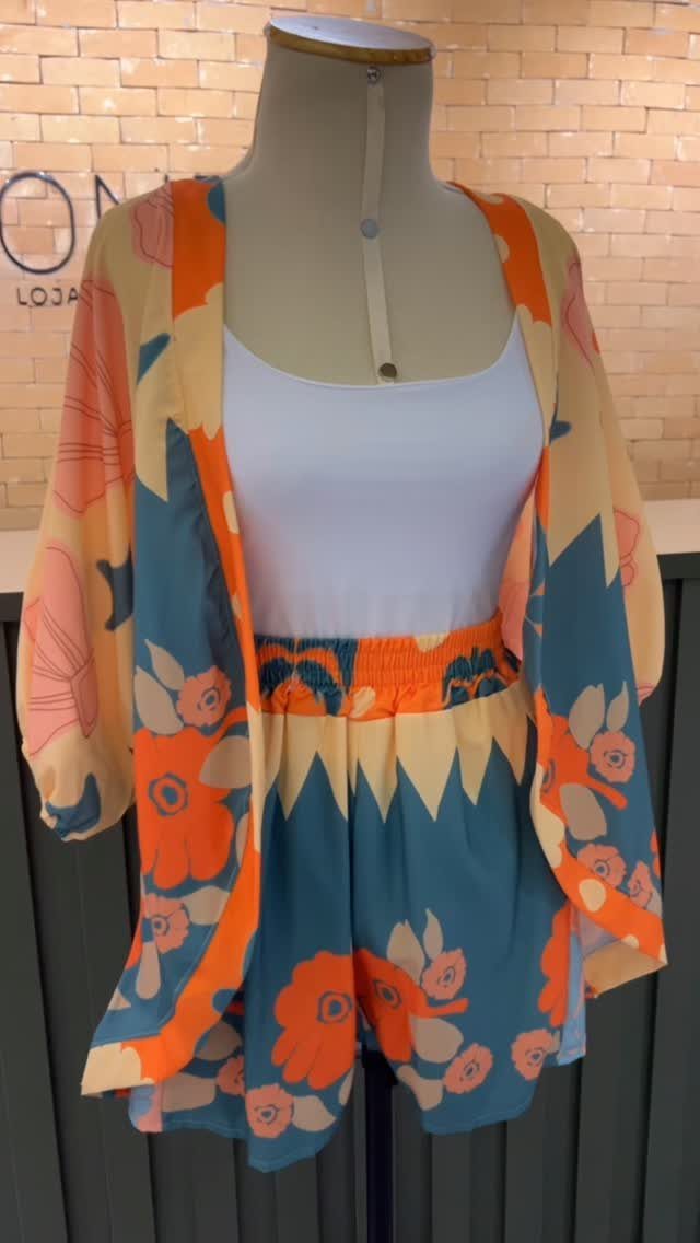 Mannequin wearing a white tank top, floral shorts, and a matching floral kimono cover-up.