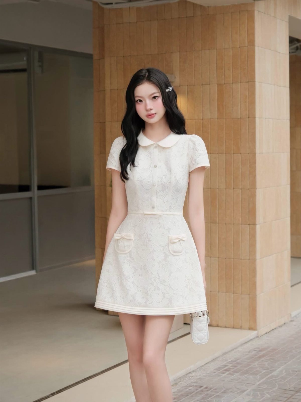 Young woman in a white short-sleeved dress with small bow accents on the pockets.