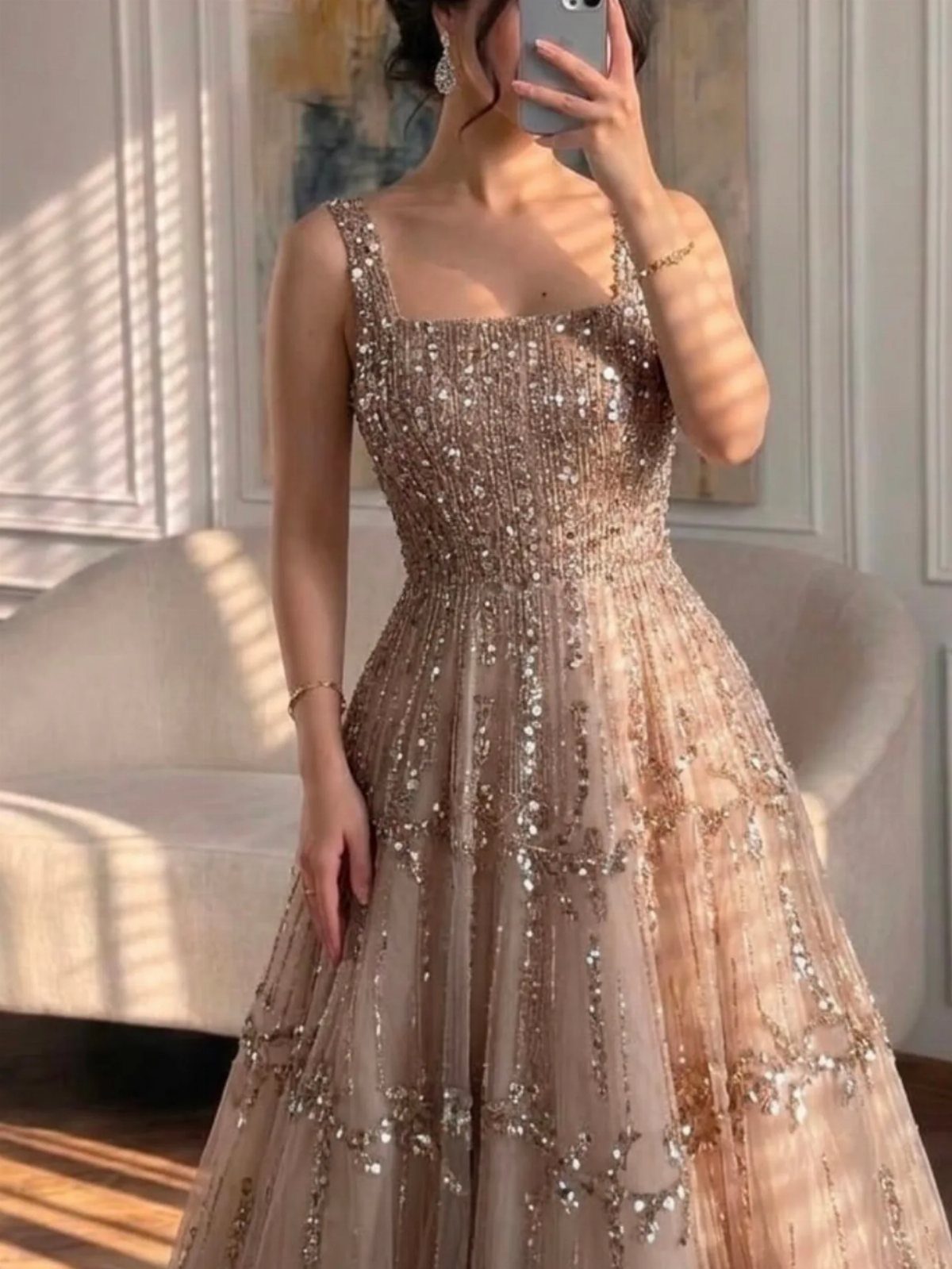 Woman in a shimmering, sequined champagne evening gown posing for a mirror selfie.