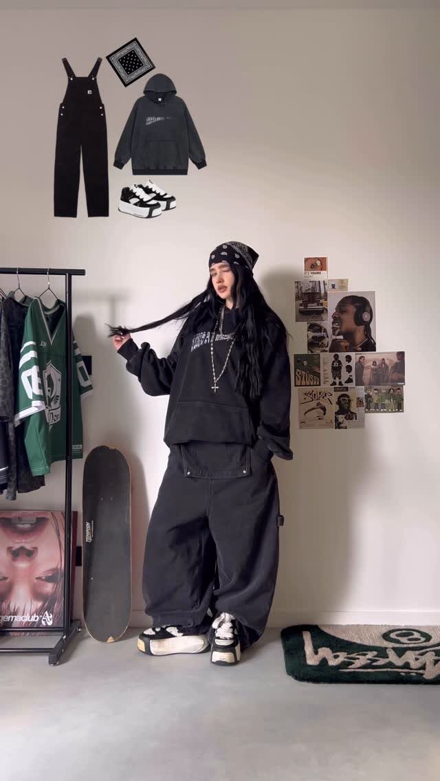 A person in baggy black streetwear posing while wearing chunky white platform sneakers.